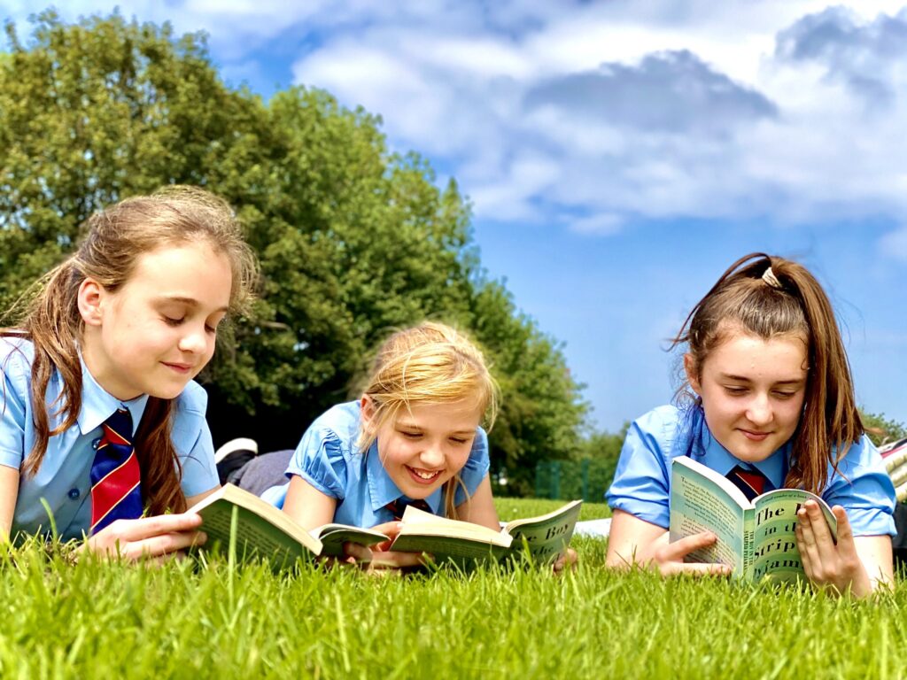 pupils reading books outdoors