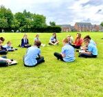 pupils sitting in a circle on grass